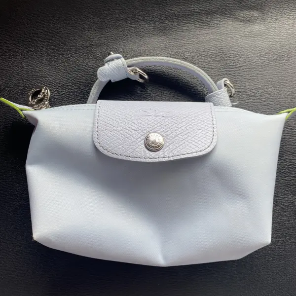 Tas selempang Longchamp biru muda dengan noda kuning sebelum dicuci di Rawatin
