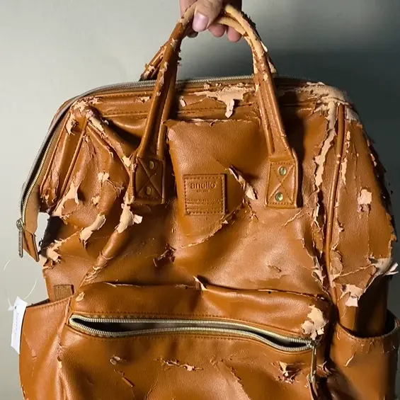 Tas ransel kulit cokelat dengan permukaan mengelupas dan rusak sebelum direparasi di Rawatin