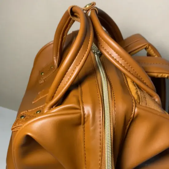 Tas ransel kulit cokelat dengan permukaan mulus kembali setelah direparasi di Rawatin